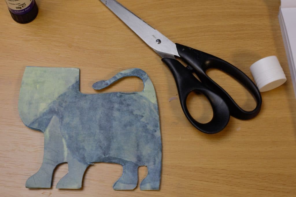 Shot of table with a lion made of card, scissors and glue